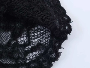 Gros plan sur la dentelle noire avec des détails de maille géométrique et broderie florale