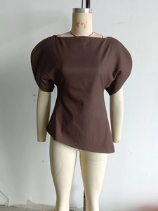 Detail view of coffee-colored off-shoulder top featuring bubble sleeves and irregular hemline