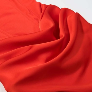 Close-up of deep red satin fabric showing high-quality silk texture and elegant drapes