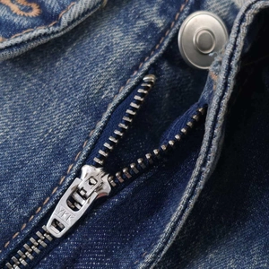 High-waisted ripped denim jeans featuring a durable YKK metal zipper and retro wash finish