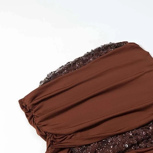 Détail du tissu plissé marron avec des paillettes scintillantes sur le bord décoré