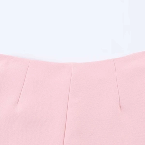 Close-up of pink high-waisted skirt showing fine woven fabric and pleated waist details