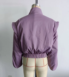 Detail of light purple stand collar puffer jacket with elastic hem and shiny fabric texture