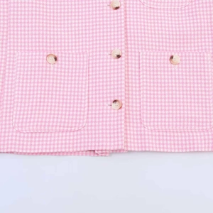 Detail der rosa Tweedjacke mit Hahnentrittmuster, Pattentaschen und marmorierten Knöpfen