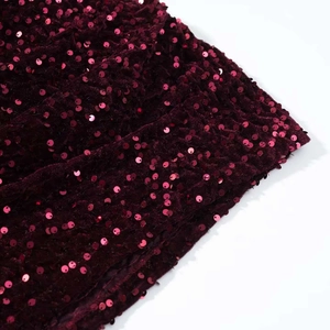 Détail macro du tissu en velours pailleté rouge vin de la robe d'été sexy à col rond