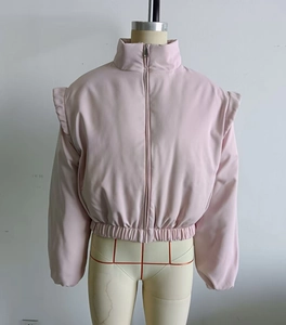 Detail of light pink stand collar jacket with ruffled shoulder accents and zip closure