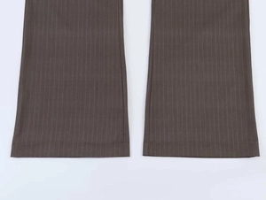 Detail of pinstripe wide-leg trousers hem featuring dark brown fabric and fine white lines