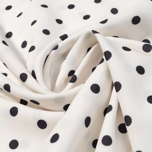 Détail du tissu à pois avec une texture tissée légère et un effet de drapé fluide