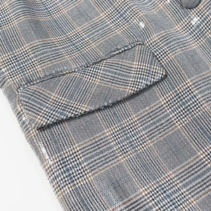 Detail of glen check blazer fabric with sparkling sequin trim on the pocket flap