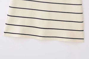 Détail du tissu en maille rayée haute densité avec des coutures précises sur l'ourlet