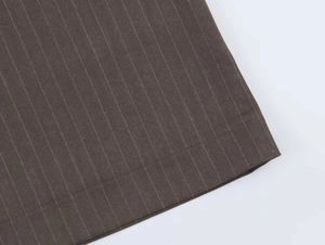 Detailed view of dark brown pinstripe fabric showing neat flat seam stitching finish