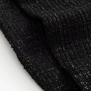 Macro view of black tweed fabric texture with shimmering silver metallic thread details