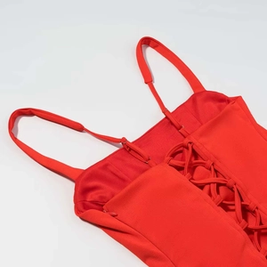 Detail of red corset dress featuring crisscross back lacing and adjustable thin straps