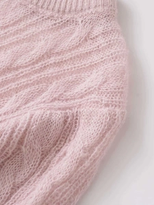 Macro shot of soft pink cable knit fabric with fluffy mohair texture and ribbed details