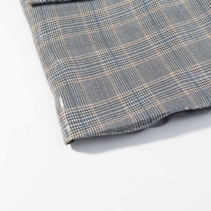 Close-up detail of British houndstooth blazer fabric with multicolor plaid texture