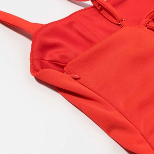 Detail of red corset dress showing invisible zipper closure and fine woven fabric texture