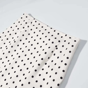 Gros plan détaillé du tissu blanc à pois noirs classiques avec coutures et texture de matière