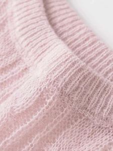 Detailed macro view of soft pink cable knit texture and fuzzy mohair style fabric