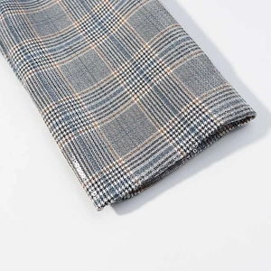 Close-up of grey glen check blazer fabric with blue and orange accent threads