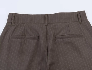 Detail of dark brown pinstripe trousers showing back waist pockets and belt loops