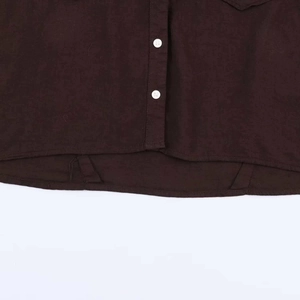 Detailed macro shot of dark brown fabric texture with white buttons and curved hemline