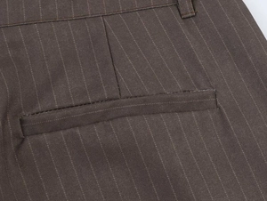 Close-up of deep brown pinstripe trousers showing belt loops and a welt pocket