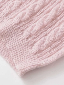 Close-up of pink cable knit fabric showing soft mohair texture and premium woven detail