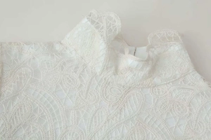 Close-up of white paisley lace neckline and intricate floral crochet details on the blouse