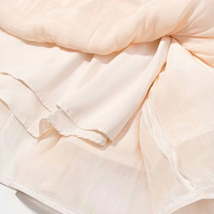 Détails de la robe longue à manches longues en mousseline crème avec finitions plissées