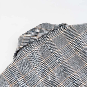 Detail of glen plaid blazer lapel with subtle sequins on premium wool blend fabric