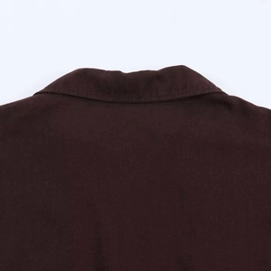 Detailed close-up of dark brown cotton shirt collar showing fine fabric texture and stitching