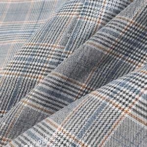Close-up of Prince of Wales check fabric with grey, blue and orange plaid patterns