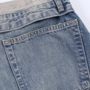 Close-up of vintage blue denim back pocket with reinforced yellow stitching details