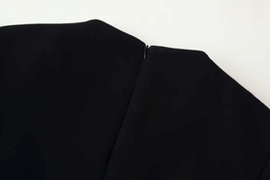 Détail de la fermeture éclair invisible sur cette robe noire à col montant ajustée