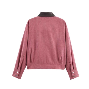 Detail van fuchsia corduroy jasje met bruine leren kraag en metalen knopen aan de manchetten