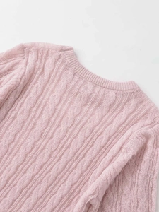 Close-up of the light pink cable knit pattern and crew neckline on a soft fuzzy sweater