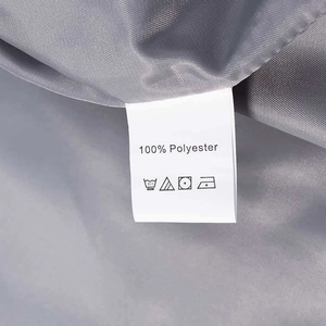 Detail view of the 100% polyester fabric texture and care label on the gray suit pants