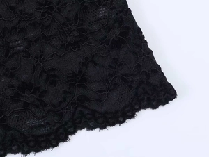 Détail du tissu en dentelle florale noire avec bords festonnés et motifs en maille