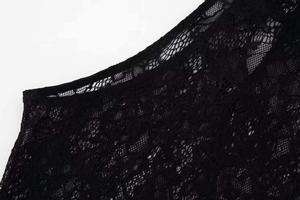 Macro detail of intricate floral lace patterns on a black summer halter dress