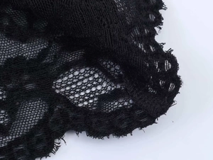 Détail du tricot noir vieilli montrant la structure en maille et les bords effilochés