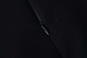 Gros plan d'une fermeture éclair invisible sur une robe noire à manches longues