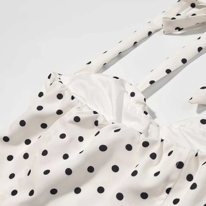 Détail du tissu à pois crème avec de fines bretelles et une doublure de qualité
