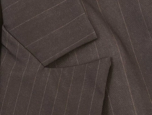 Close-up detail of dark pinstripe blazer fabric with elegant notch lapel texture