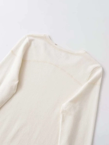 Detailopname van de ronde halslijn en schoudernaden van een beige gebreide top voor dames
