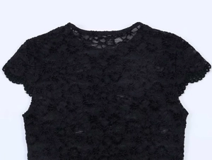 Détail de la dentelle florale noire au crochet sur l'encolure et l'épaule du haut