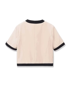 Détail du dos d'un cardigan beige avec des bordures noires contrastées et une coupe chic