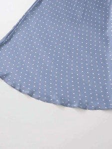 Detail view of light blue polka dot satin skirt hem showing soft wavy draped texture