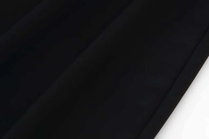 Detail of black lace knit dress showing fine fabric texture and neat edge stitching