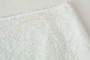 Detail of the high-waisted crochet lace skirt with intricate floral patterns and size S tag