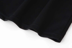Close-up of black knit fabric hem with precise double-needle stitching and smooth texture
